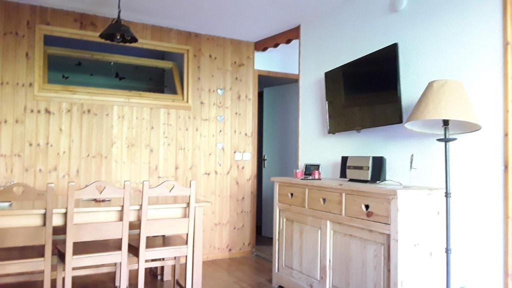 une salle à manger avec une table, des chaises et une télévision dans l'établissement Residence la Dame Blanche, à Puy-Saint-Vincent