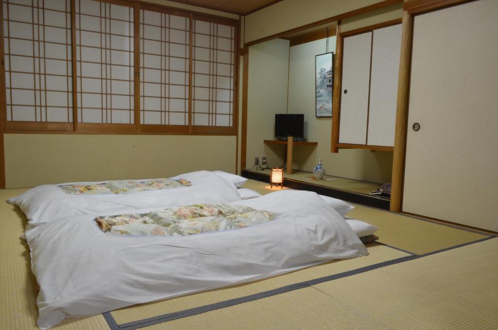 - une chambre avec 2 lits dans une chambre avec fenêtres dans l'établissement Nissho Besso, à Kyoto