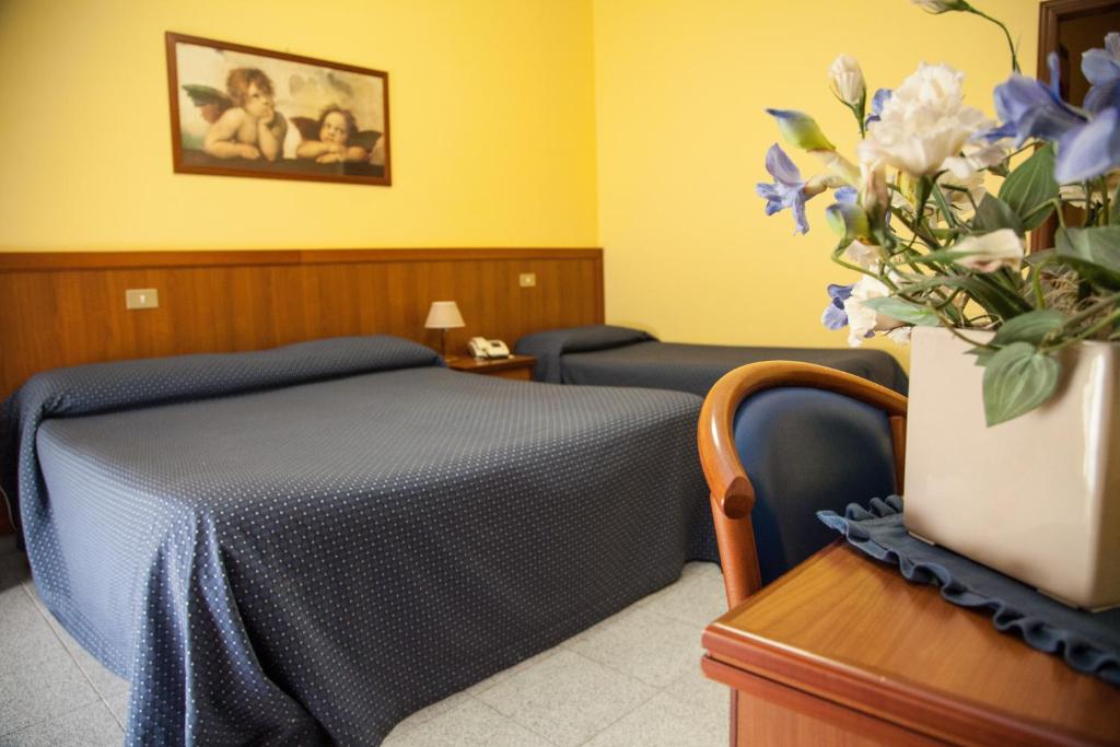 - une chambre avec un lit et un vase de fleurs dans l'établissement Hotel Rio, à Vasto 38 autres photos