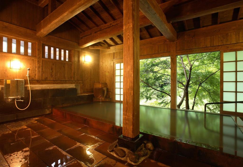 Cette grande chambre dispose d'une baignoire et de fenêtres. dans l'établissement Yumerindo, à Minamioguni