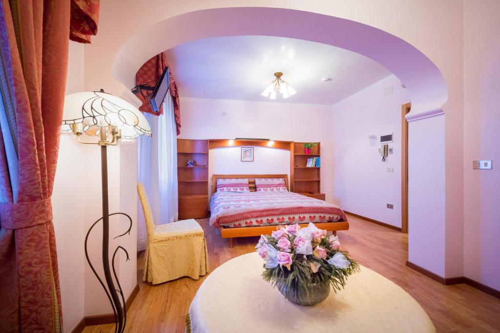 une chambre avec un lit et une table avec des fleurs dessus dans l'établissement Albergo Ristorante Fabrizio, à Caorle
