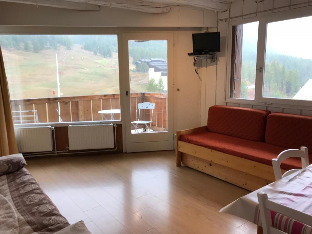 d'un salon avec un canapé et un balcon. dans l'établissement Face aux pistes, à Montgenèvre