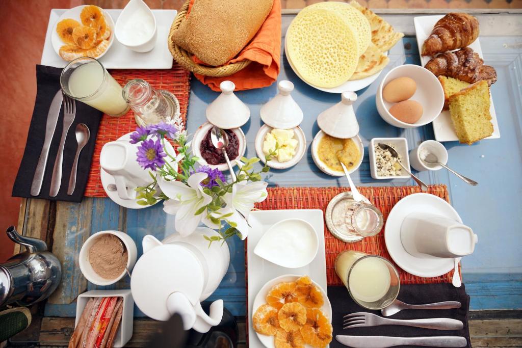 - une table avec des plats blancs et des aliments pour le petit-déjeuner dans l'établissement The Repose, à Sale