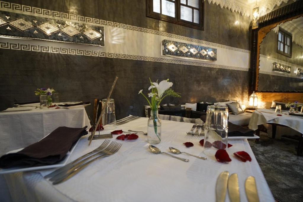 - une table avec des ustensiles et un vase de fleurs dans l'établissement The Repose, à Sale