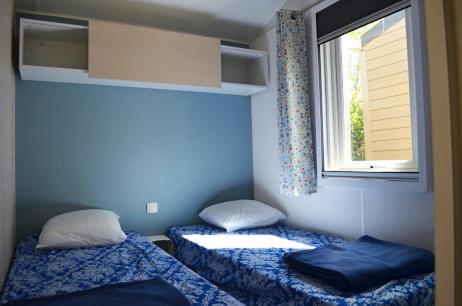 deux lits dans une chambre avec une fenêtre dans l'établissement Camping Parc Mogador, à Sanary-sur-Mer 37 autres photos