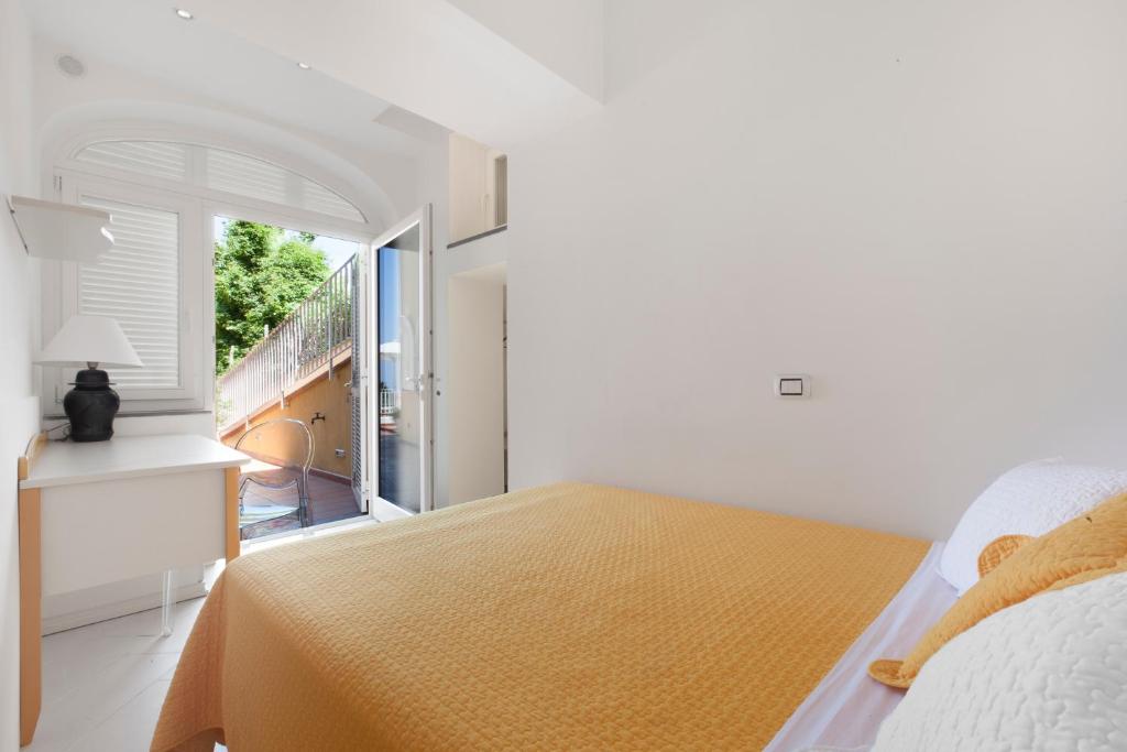 une chambre blanche avec un lit et une fenêtre dans l'établissement Villa & SPA Le Tore, à Sorrente