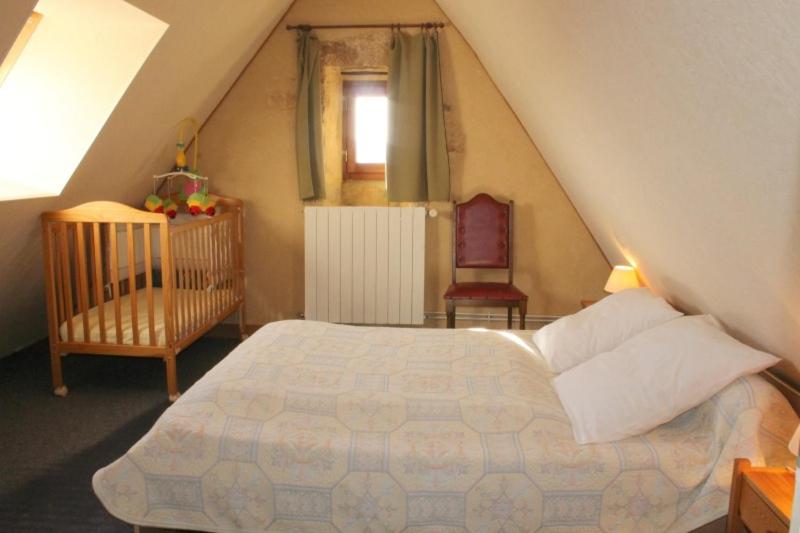 - une chambre mansardée avec un lit et un lit bébé dans l'établissement GITE LES PIERRES CHAUDES, à Veyrignac