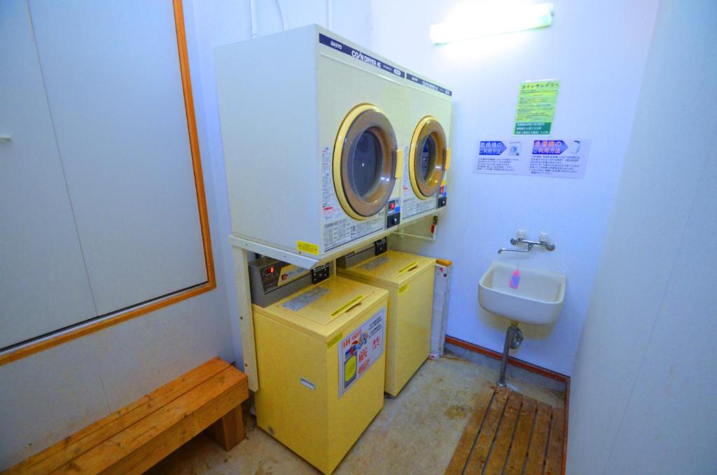 une petite salle de bains avec un lave-linge et un lavabo dans l'établissement Ryoufuso, à Tsu