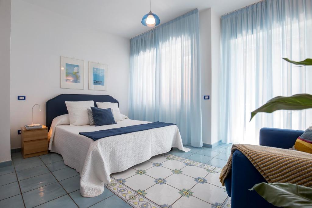 - une chambre avec un lit doté d'une tête de lit bleue et de fenêtres dans l'établissement Angelina Residence, à Maiori 51 autres photos