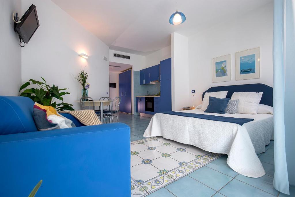 - une chambre bleue et blanche avec un lit et un canapé dans l'établissement Angelina Residence, à Maiori