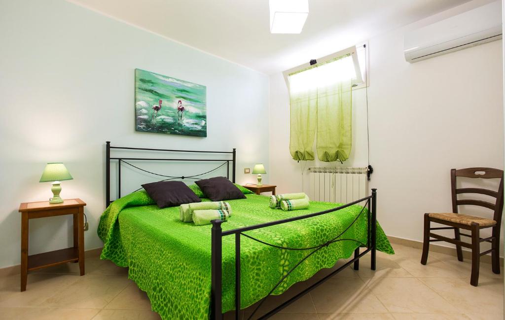 - une chambre avec un lit vert et une chaise dans l'établissement Alghero Villa Morena with exclusive swimming pool and large garden, à Alghero 40 autres photos