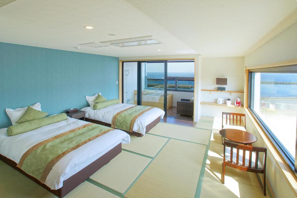 deux lits dans une chambre avec vue sur l'océan dans l'établissement SEVEN SEAS HOTEL ITO (セブンシーズホテル）, à Itō 37 autres photos