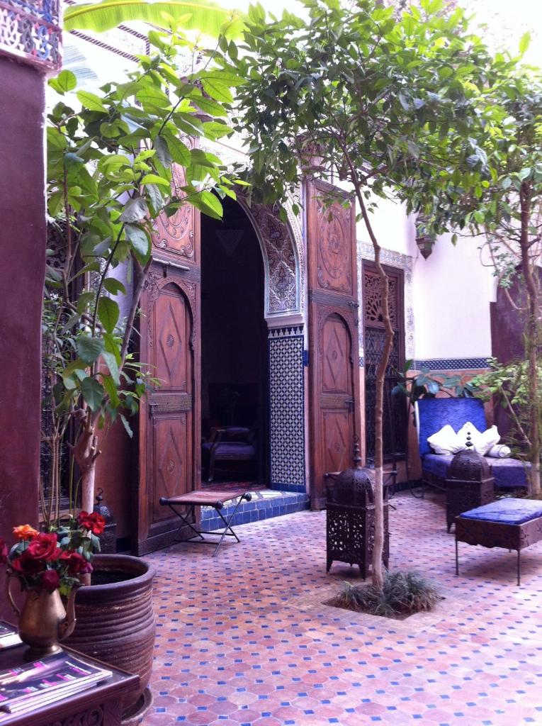 - une entrée menant à une cour avec une grande porte en bois dans l'établissement Riad Jenaï L'Authentique, à Marrakech