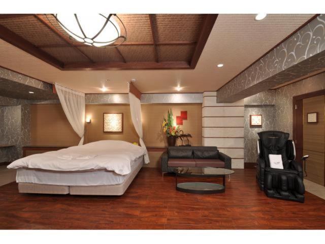 une chambre avec un grand lit et un canapé dans l'établissement Hotel ShaSha Resort Suma, à Kobe 4 autres photos