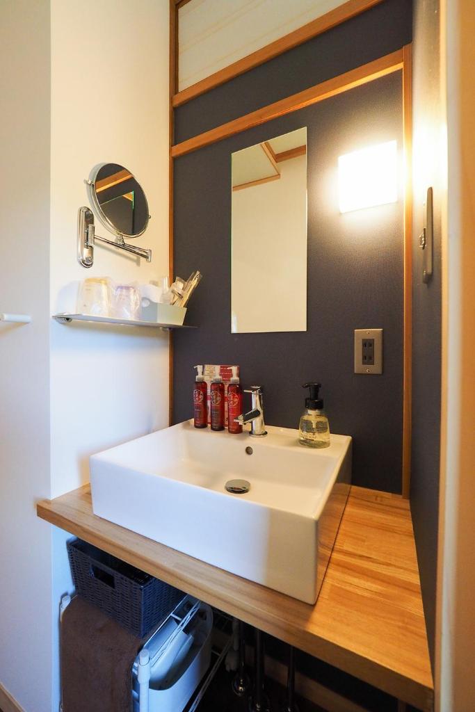 une salle de bain avec un lavabo blanc et un miroir dans l'établissement Arai Ryokan, à Izu 37 autres photos