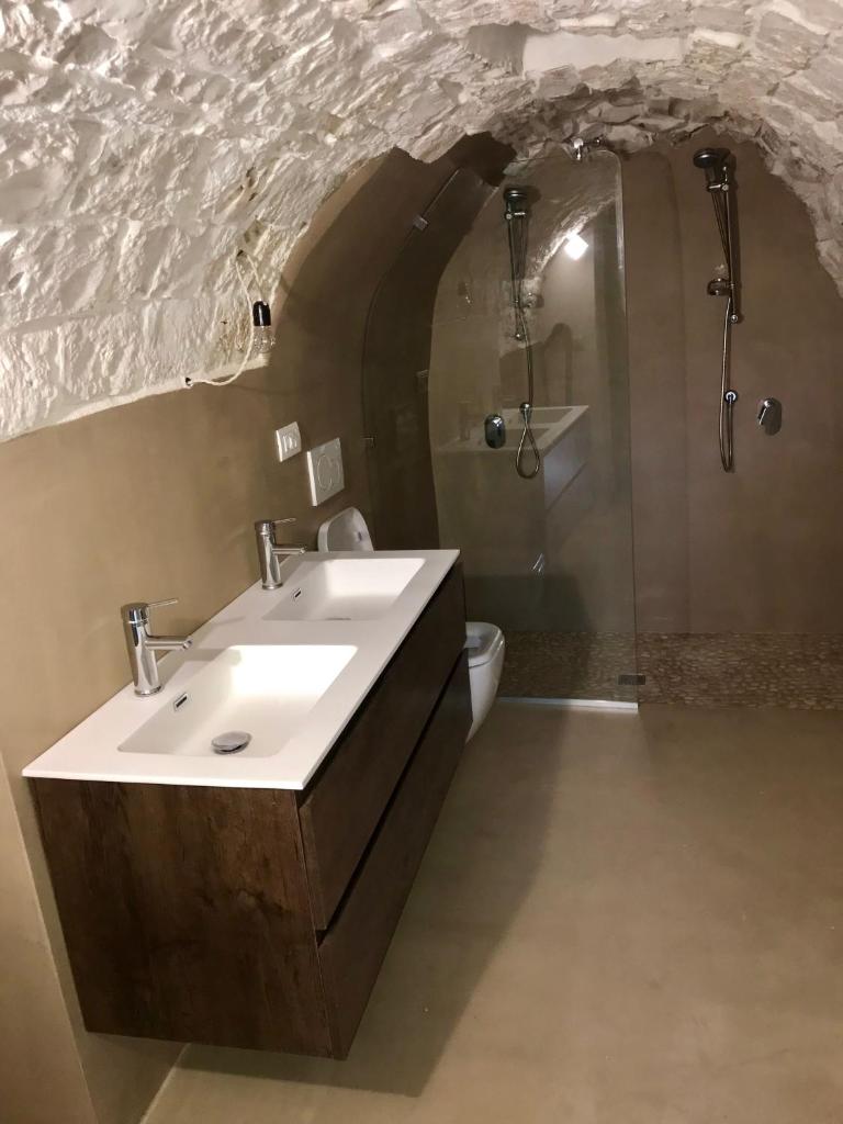 une salle de bain avec un lavabo et une douche dans l'établissement Trulli Storie di Puglia - Private Pool, à Polignano a Mare 103 autres photos