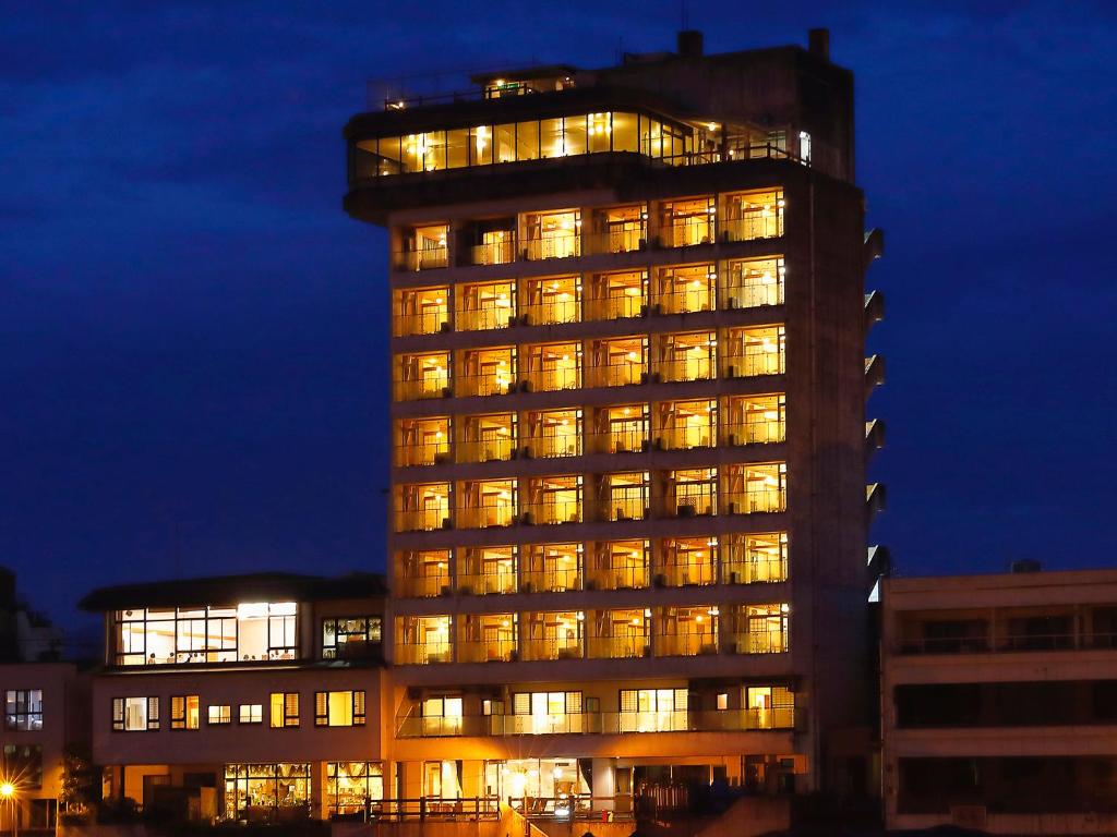 un grand bâtiment avec de nombreuses fenêtres la nuit dans l'établissement Mikuma Hotel, à Hita