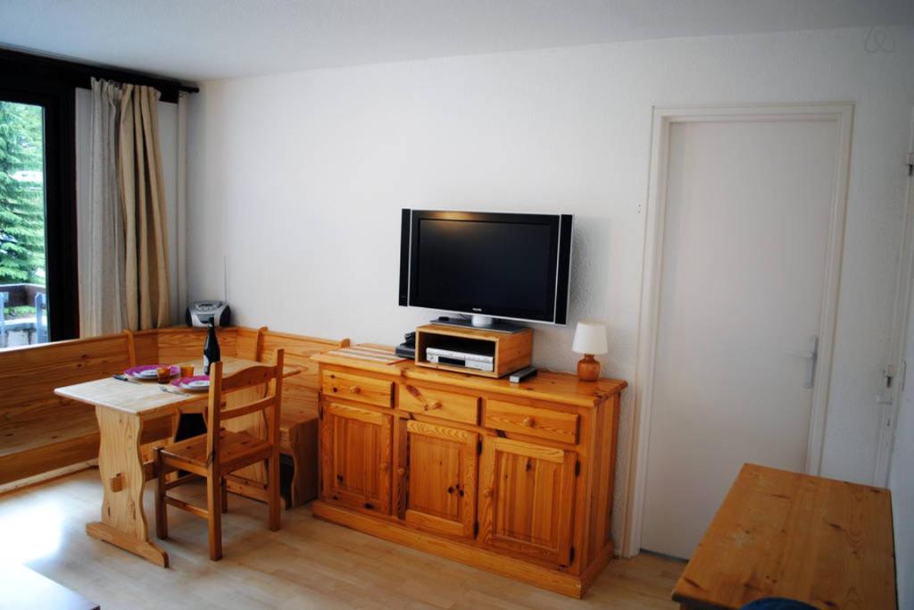 un salon avec une télévision sur un meuble en bois dans l'établissement Au pied des pistes (Le Corbier/73), à Villarembert