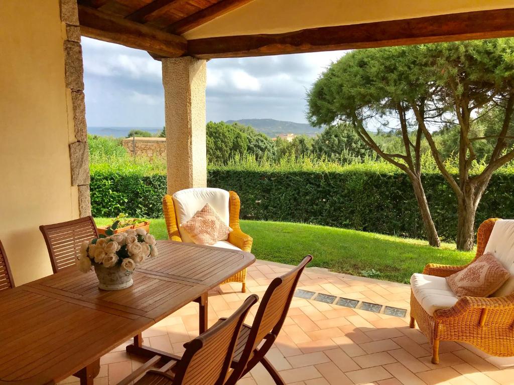 une table et des chaises en bois sur une terrasse dans l'établissement Villa vista mare con piscina, à San Teodoro