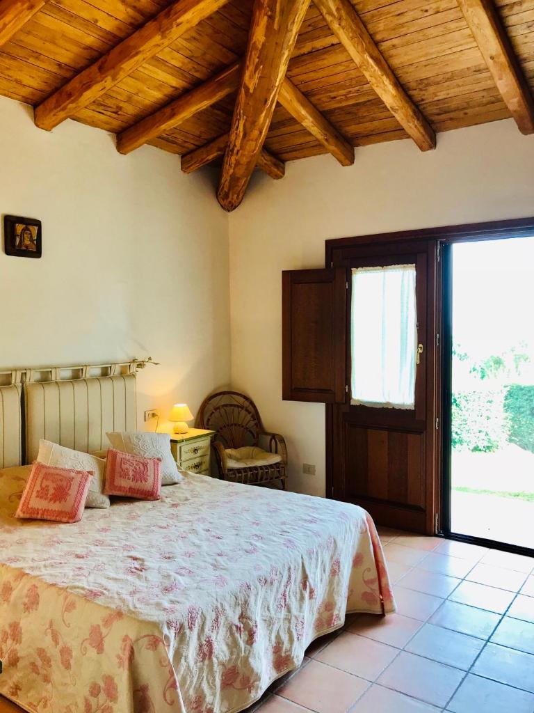 une chambre avec un lit et une grande fenêtre dans l'établissement Villa vista mare con piscina, à San Teodoro