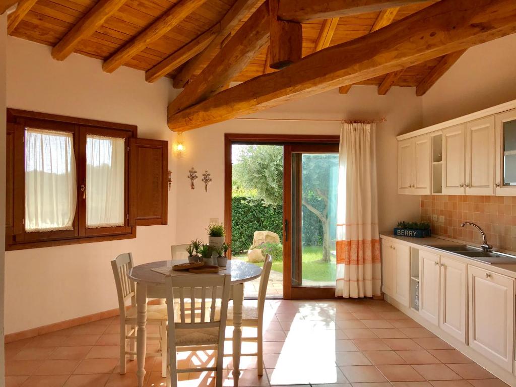 une cuisine avec une table et des chaises et une fenêtre dans l'établissement Villa vista mare con piscina, à San Teodoro