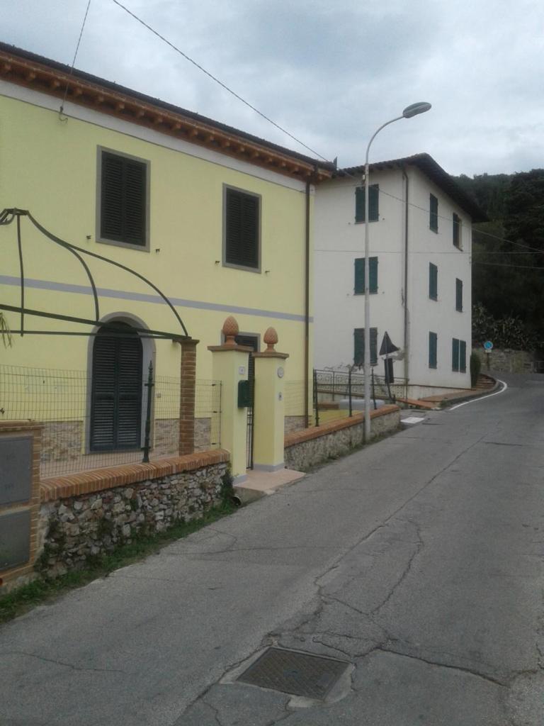 une rue vide avec deux bâtiments et un feu de rue dans l'établissement CA' MENEGHETTI, à Massaciuccoli