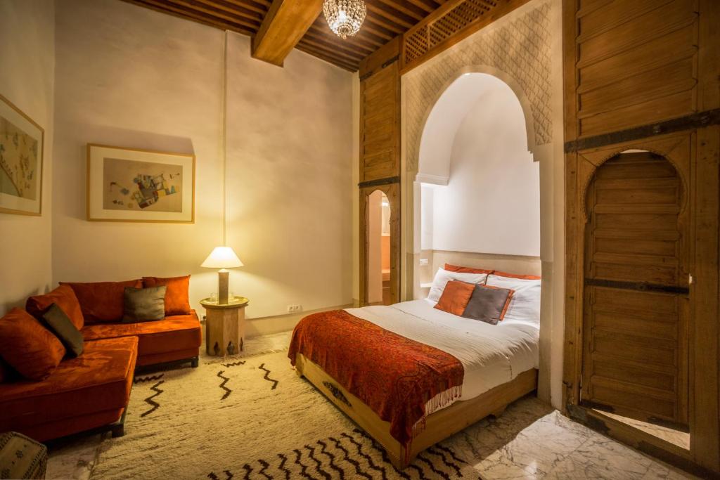 une chambre avec un lit et un canapé dans une pièce dans l'établissement La Maison Maure, à Fès