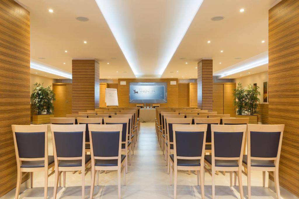 une salle de conférence avec des chaises et un écran de projection dans l'établissement Park Hotel Marinetta - Beach & Spa, à Marina di Bibbona 99 autres photos