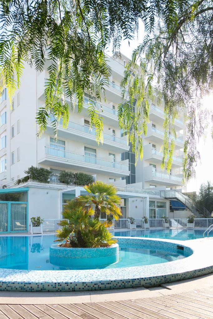 un hôtel avec une piscine devant un bâtiment dans l'établissement Hotel Excelsior, à Vasto