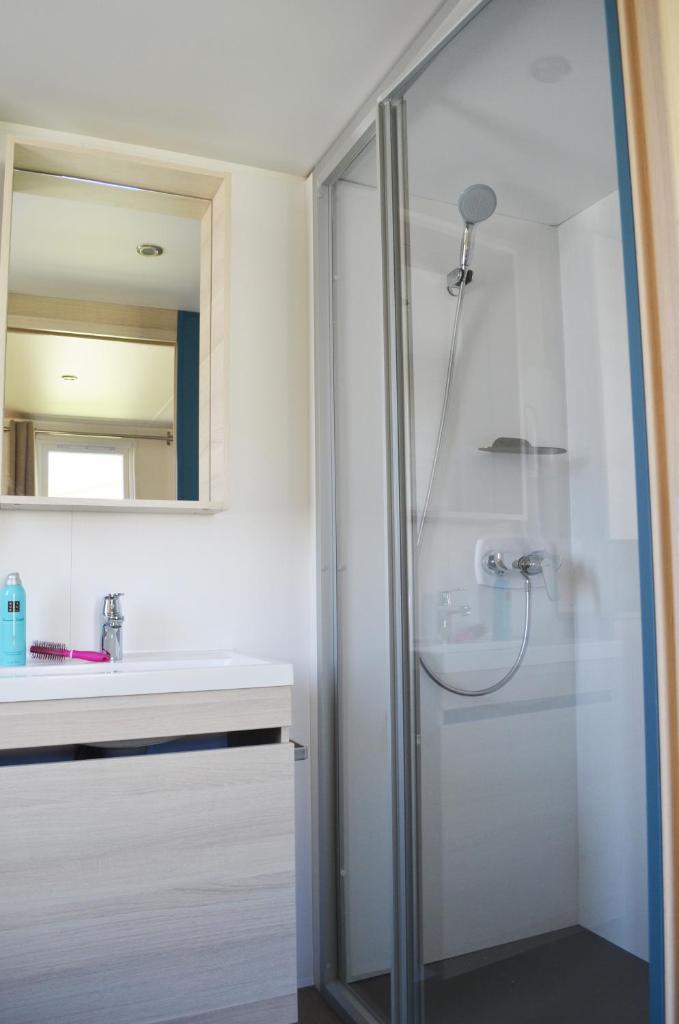 une salle de bain blanche avec une douche et un lavabo dans l'établissement Camping Parc Mogador, à Sanary-sur-Mer
