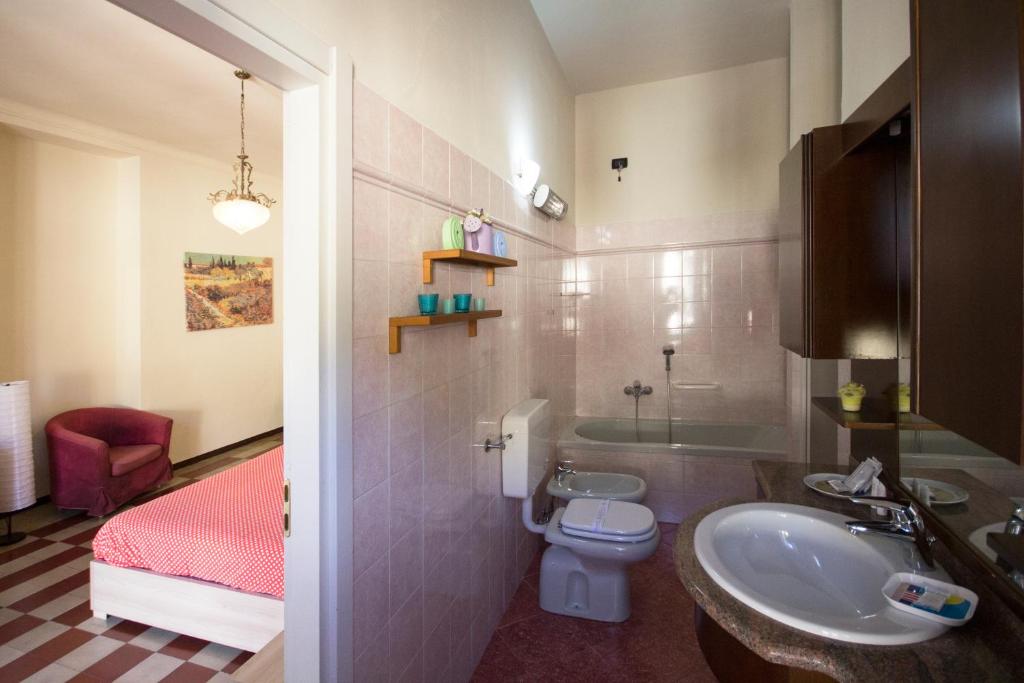 une salle de bain avec un lavabo et des toilettes et un lit dans l'établissement Albergo Sala, à Valbrona