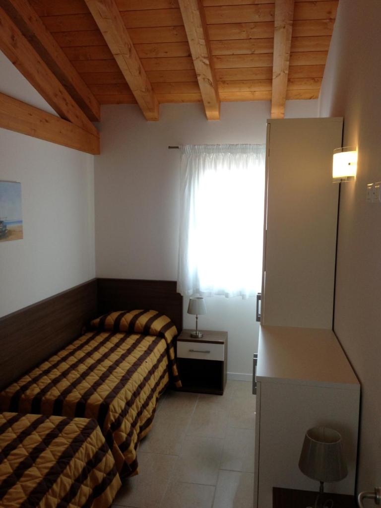 une chambre avec deux lits et une fenêtre dans l'établissement Villaggio Margherita, à Caorle 47 autres photos
