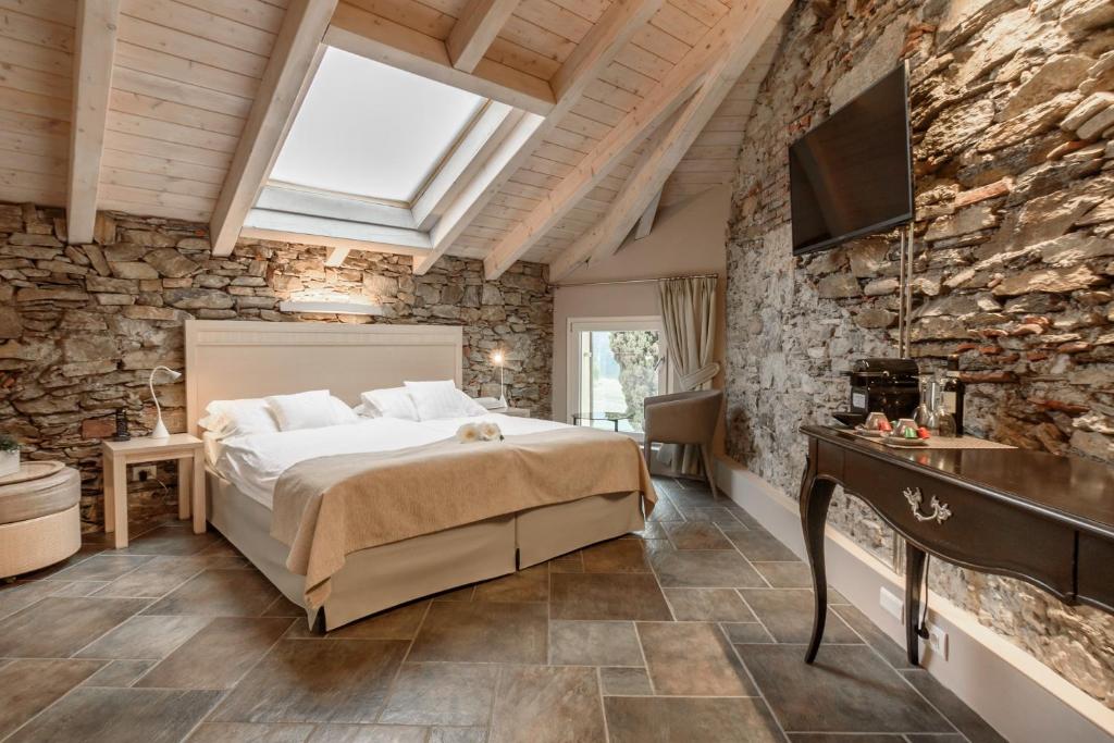 une chambre avec un lit dans un mur de pierre dans l'établissement Relais Villa Porta, à Luino