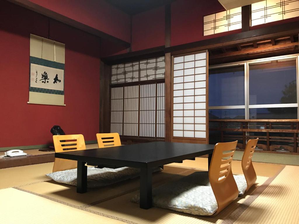 une salle à manger avec une table et des chaises noires dans l'établissement Katsuzakikan, à Tsubata 10 autres photos