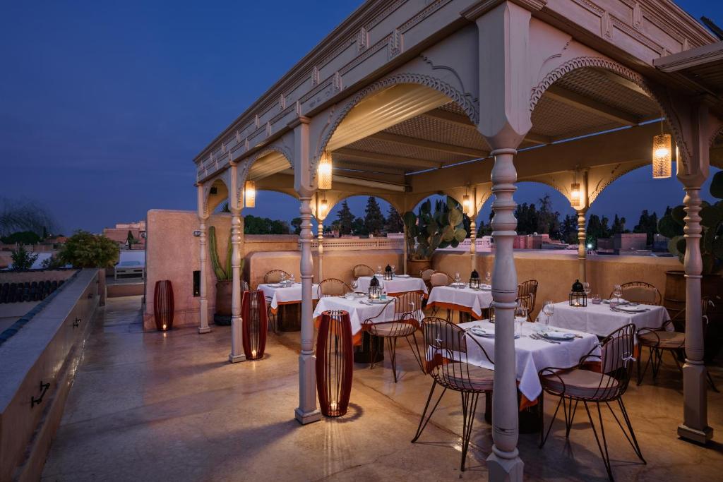 un restaurant avec des tables et des chaises blanches sur la terrasse dans l'établissement 72 Hotel & Spa, à Marrakech