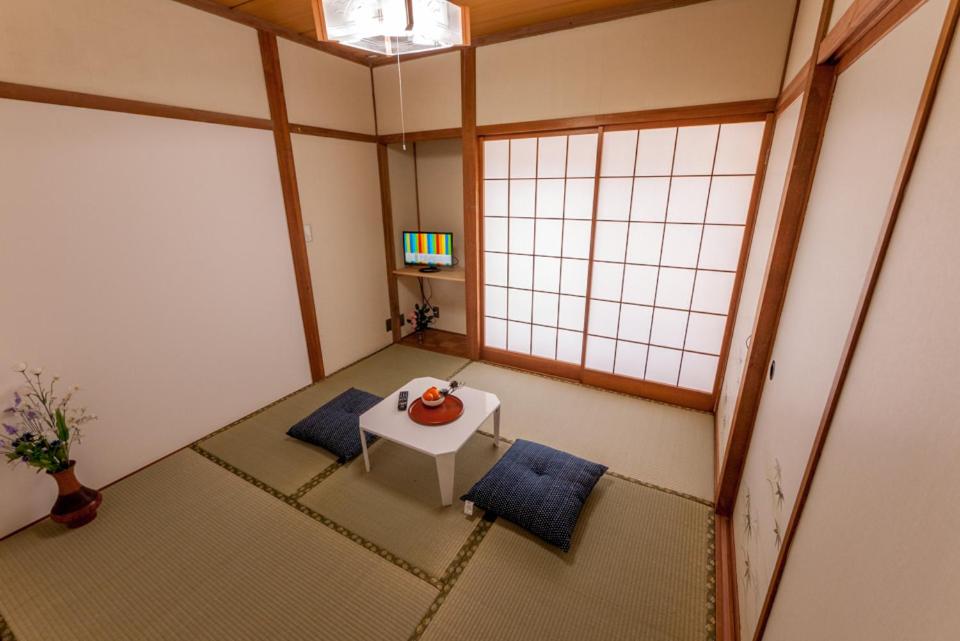 Cette petite chambre comprend une table et deux oreillers bleus. dans l'établissement 金剛寺 宿坊 成穂院, à Matsukawa