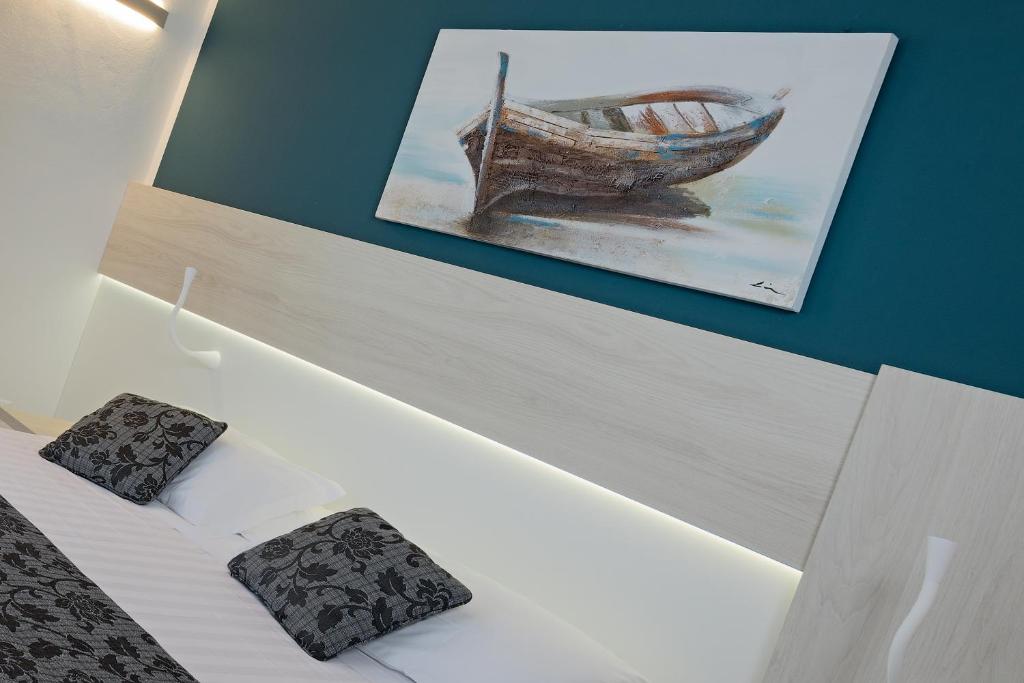 une chambre avec une photo d'un bateau sur le mur dans l'établissement Hotel il Delfino, à San Vincenzo