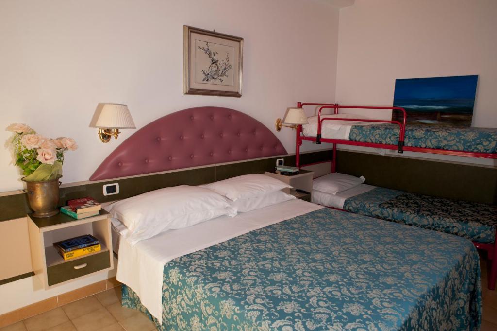 une chambre d'hôtel avec un lit et deux lits superposés dans l'établissement Villa Dei Romanzi, à Tortoreto Lido