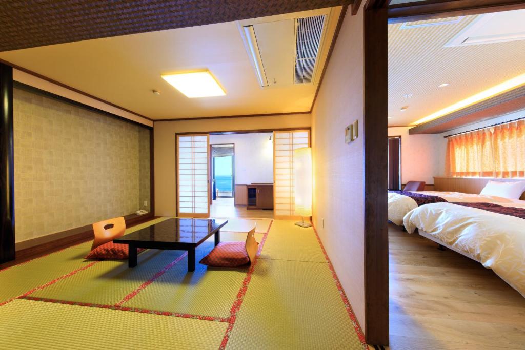 une chambre avec une table et un lit et une pièce dans l'établissement Seaside Hotel Mimatsu Ooetei, à Beppu