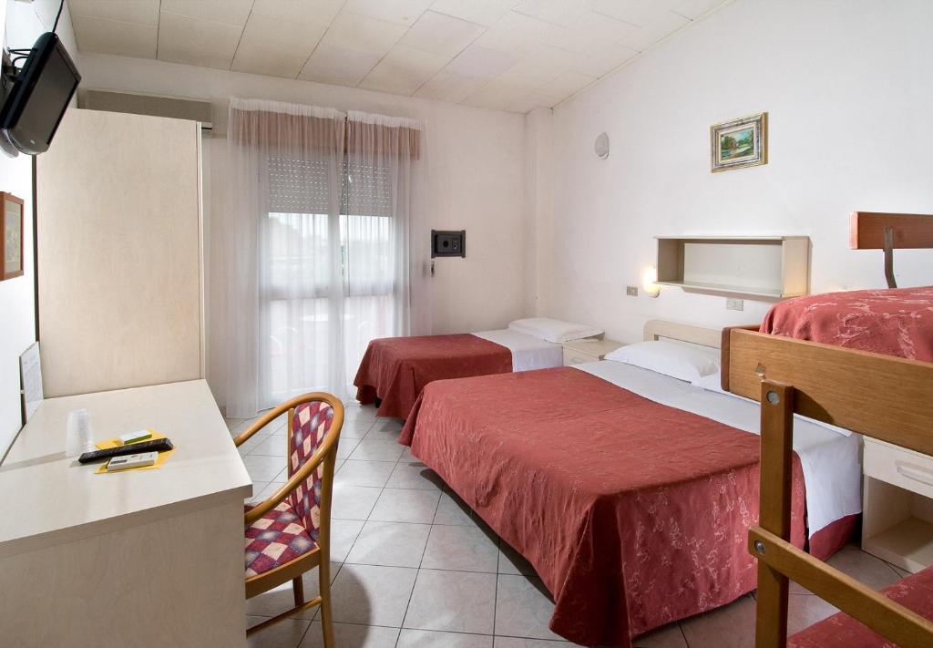 une chambre d'hôtel avec deux lits et une télévision dans l'établissement Hotel Zenith, à Cervia