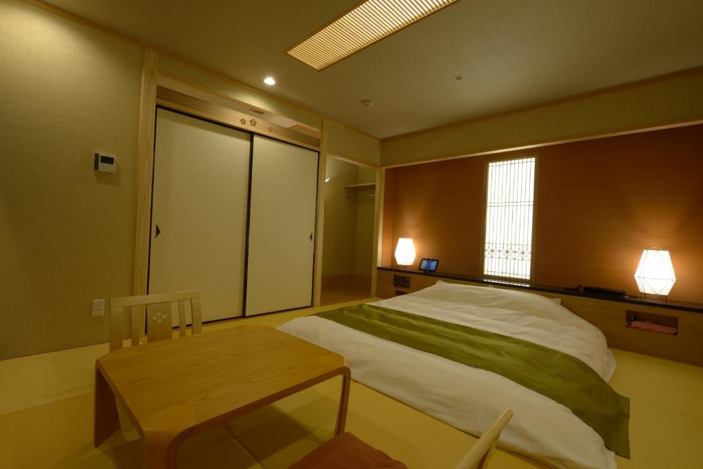 une chambre avec un grand lit et une table dans l'établissement Hotel 5stars (Adult Only), à Takamatsu 1 autre photo