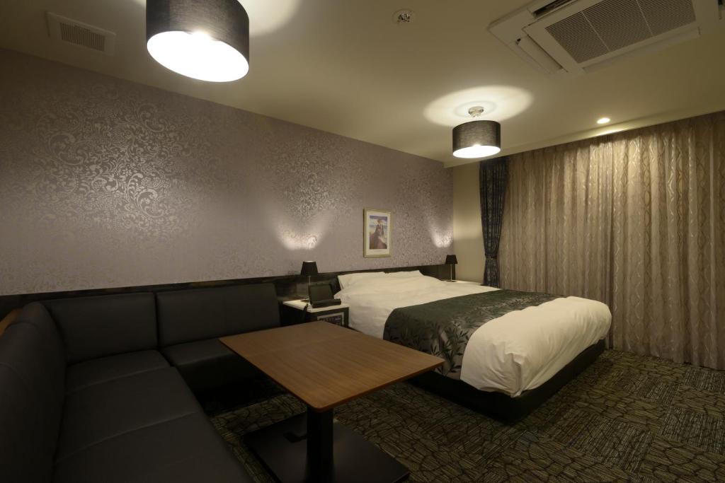 une chambre d'hôtel avec un lit et un canapé dans l'établissement Hotel 5stars (Adult Only), à Takamatsu