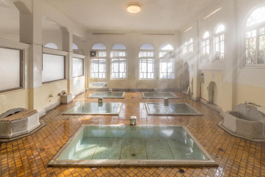 une grande chambre avec cinq lavabos dans un bâtiment avec fenêtres dans l'établissement Sekizenkan Kashotei Sanso, à Nakanojo 37 autres photos