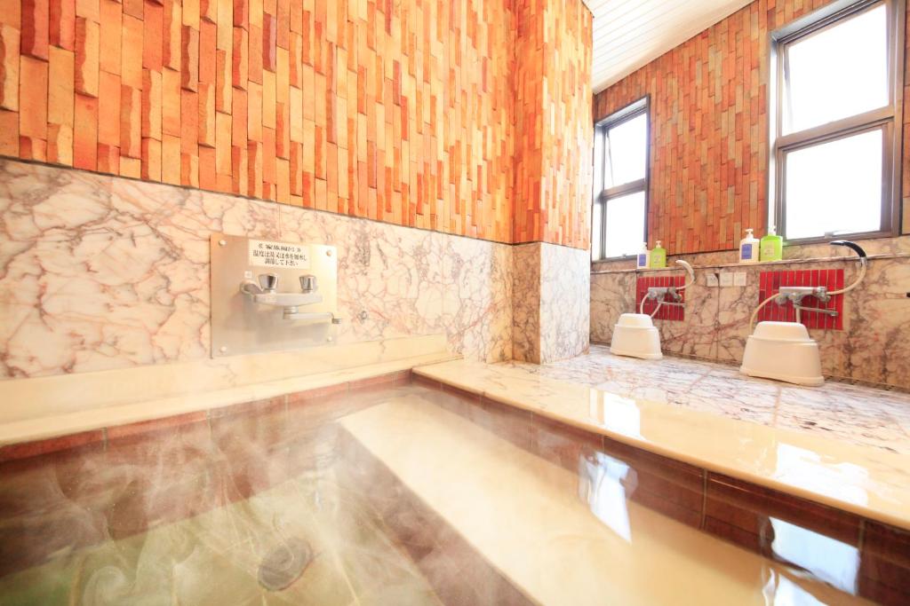 une grande salle de bain avec une baignoire et un lavabo dans l'établissement Fuji Green Hotel, à Fuji