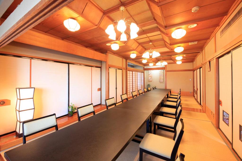 une longue salle de conférence avec une grande table et des chaises dans l'établissement Fuji Green Hotel, à Fuji