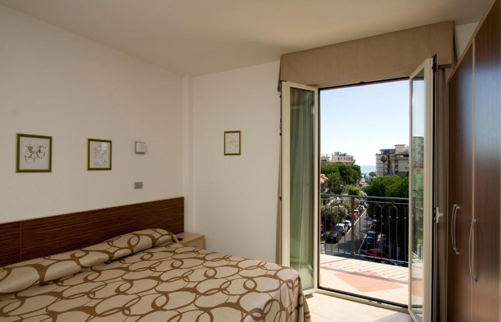 une chambre avec un lit et une porte coulissante en verre dans l'établissement Hotel Fenix, à San Benedetto del Tronto 24 autres photos