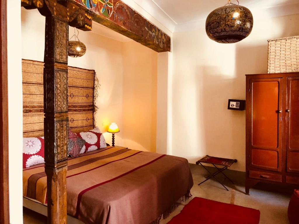 une chambre avec un grand lit dans une pièce dans l'établissement Riad Le Coq Berbère, à Marrakech