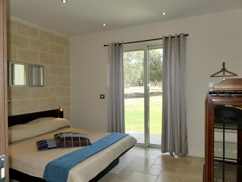 une chambre avec un lit et une porte coulissante en verre dans l'établissement Villa M, à Specchiolla 32 autres photos