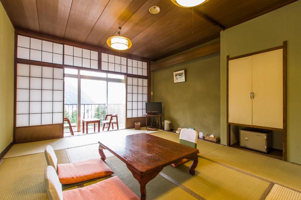un salon avec une table et des chaises en bois dans l'établissement Takahan, à Yuzawa