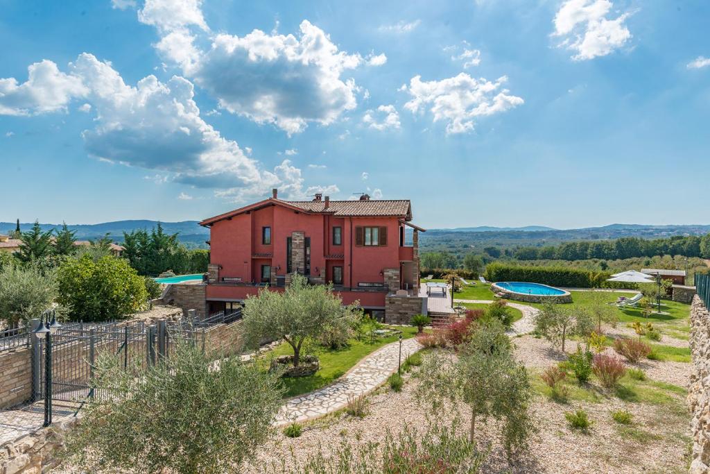 une maison rouge au milieu d'une cour dans l'établissement Casale La Desdemona, à Sutri